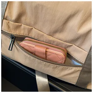 Nahaufnahme der Reisetasche Seitentasche mit einem stilvollen rosa gesteppten Portemonnaie darin.