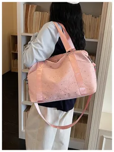 Stylish pink star-printed travel duffel bag worn on shoulder. Ideal for commute and trips.