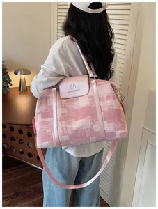 Detail view of trendy pink oil painting pattern travel duffel bag with shoulder strap.