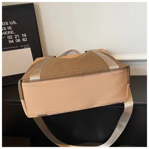 Detailansicht der stylischen Reisetasche mit Karomuster und robusten silbernen Gurten.