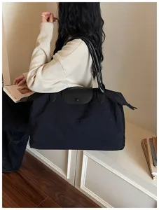Detailansicht einer großen schwarzen Nylon-Reisetasche, leichtere Schultertasche mit Lederklappe.