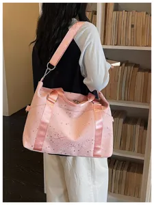 Pink travel duffel bag with star print and shoulder strap, stylish gym and commuter bag.