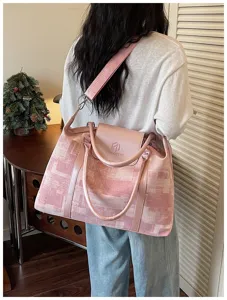 Pink abstract pattern travel duffel bag detail showcasing dual handles and front flap branding.