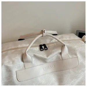 Vue détaillée du sac de voyage blanc élégant avec texture marbre et patch logo élégant.