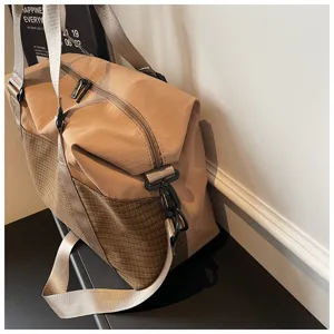 Detailaufnahme der Reisetasche, stilvolles khaki Karo-Design für Pendler und Fitnessbereich.