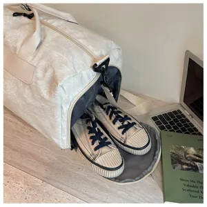 Détail du sac de voyage avec compartiment pour chaussures sur le bureau très moderne.