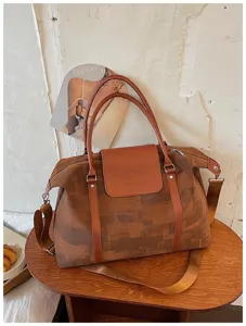 Detail view of the brown canvas travel duffel bag with geometric oil painting pattern.