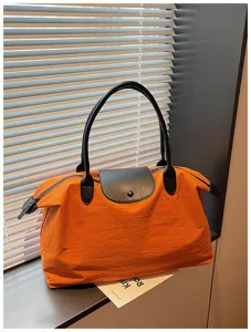 Grosse reise tote tasche, orange nylon schultertasche mit schwarzem ledergriff und klappe.