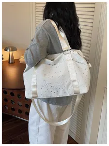 White starry travel shoulder bag for women, stylish large capacity commuter bag with wide strap.
