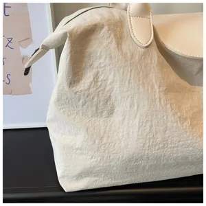 Detailansicht der großen Reisetasche, Knitteroptik Stoff und schönes Lederklappe Design.