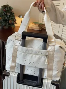 White travel duffel bag with starry print and luggage sleeve, perfect for weekend and commuting.