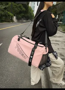 Pink travel duffel bag with large capacity, shoulder strap and side mesh pocket for sports.