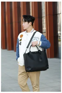 Model carrying black nylon travel tote bag, spacious design detail view, outdoor.