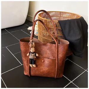 Brown PU leather tote bag detail view with stylish bunny charm and spacious main compartment.