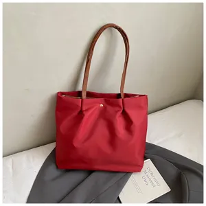 Red shoulder tote bag for daily commute, minimalist travel handbag with brown straps.