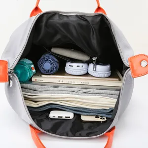 Large capacity travel duffel bag with orange handles, interior view showing storage.