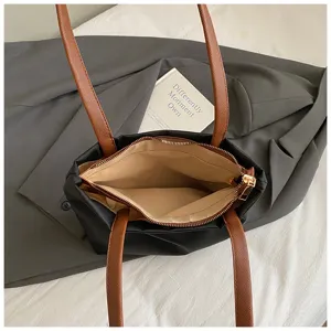 Detail view of the black nylon tote bag interior, showing zipper pocket and spacious lining.