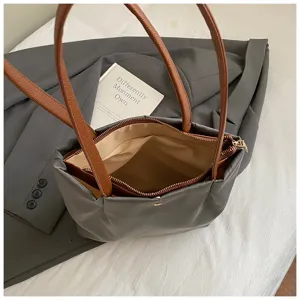 Grey shoulder tote bag detail view, casual commuting style with brown straps and zipper.