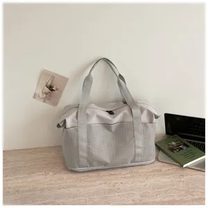Spacious grey travel duffel bag with grid pattern texture, ideal for gym and weekend trips.