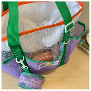 Clear mesh beach tote bag with green straps, purple front pocket and small detachable pouch.