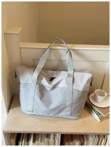 Stylish large gray travel duffel bag with durable handles and geometric textured panel for daily use.