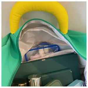 Dettaglio interno della borsa da viaggio verde con grande capienza e scomparti ordinati.