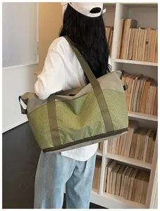 Detail view of large capacity travel duffel bag with green plaid design and sturdy straps.