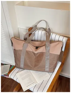 Detail view of the large capacity expandable travel bag with stylish two-tone grid design.
