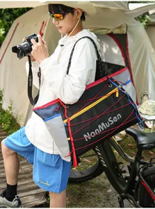 Outdoor travel drawstring tote bag with colorful bungee cords and mesh side pockets for sports.