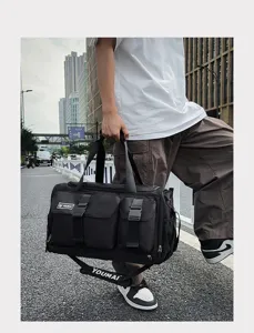Urban street style detail view of a black multi-pocket sports gym and travel duffel bag.