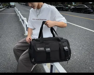 Detailed shot of a black sports duffel bag with multiple pockets and durable fabric outdoors.