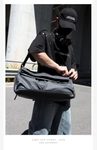 Detail view of large capacity dark grey shoulder travel bag in urban outdoor setting.