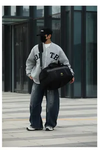 Black large capacity duffel travel bag outdoor detail view showcasing durable fabric and handle.