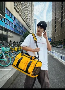 Detailed shot of yellow travel duffel bag with multi pockets, strap and mesh side pocket outdoors.