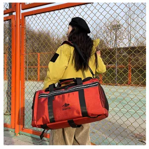 Detailed view of the red travel duffel bag outdoor scene showing capacity and strap.