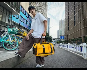 Urban street scene displaying a vibrant yellow travel duffel bag with practical multi-pockets.