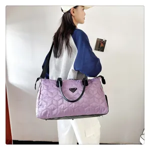 Vue detaillee du grand sac de voyage matelasse violet avec lanieres noires et motif.