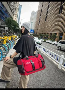 Large capacity red duffel bag for travel, gym, and sports with durable fabric and straps.