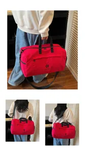 Detailed view of red travel duffel bag, showing shoulder strap and daily wearing style.