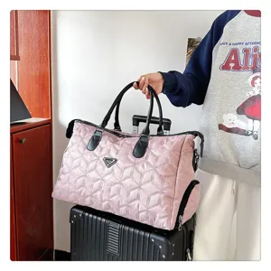 Vue détaillée du sac de voyage matelassé en nylon avec poignées doubles et grande capacité.