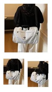 Detailed showcase of large capacity white travel duffel bag with black straps worn.