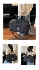 Detail view of black travel duffel bag showing multiple carrying ways and front zipper pocket.