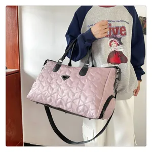 Grand sac de voyage matelassé avec compartiment à chaussures et bandoulière réglable.