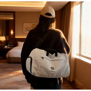 Detail shot of a large-capacity solid color travel duffel bag in a hotel room scene.