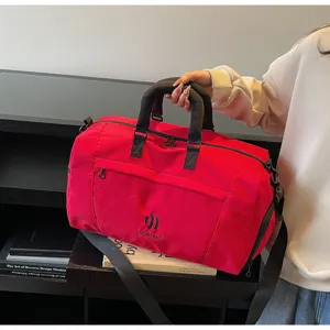 Red travel duffel bag detail, large capacity nylon fitness gym bag with carry handles.