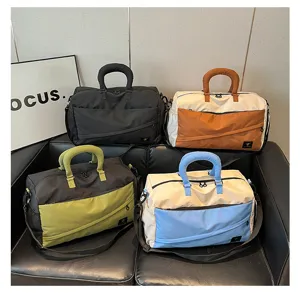 Color-blocked short-distance travel duffel bag with soft handles for commuting and fitness.