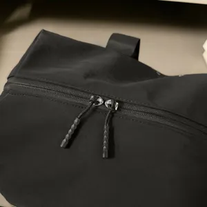 Close-up detail of black travel bag zipper, durable fabric and texture pull cord.