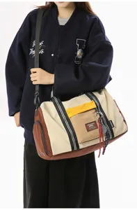 Detail view of the large capacity travel duffel bag with color block design and sturdy straps.