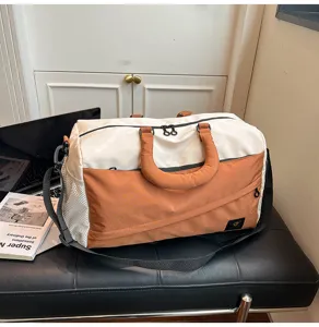 Detail view of the two-tone travel duffel bag, highlighting fabric texture and sturdy hardware.