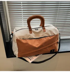 Color-block travel duffel bag with thick handle and shoulder strap for fitness commuting.